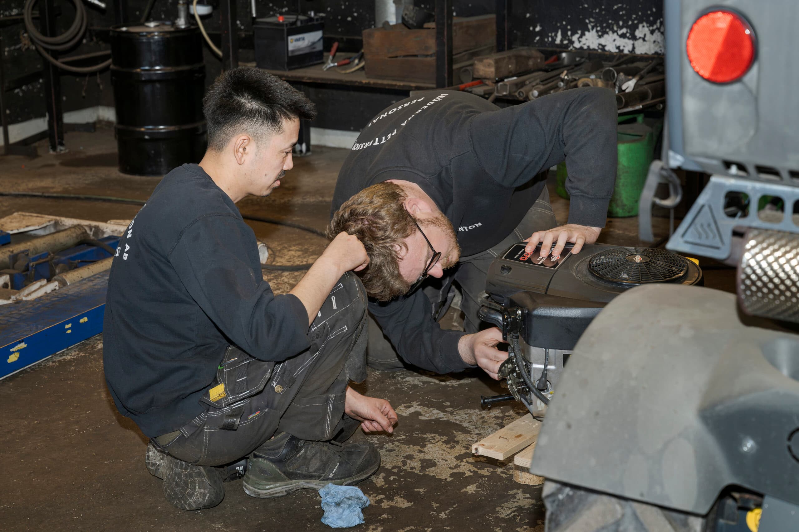 Två mekaniker i Bröderna Petterssons verkstad arbetar med maskinreparation